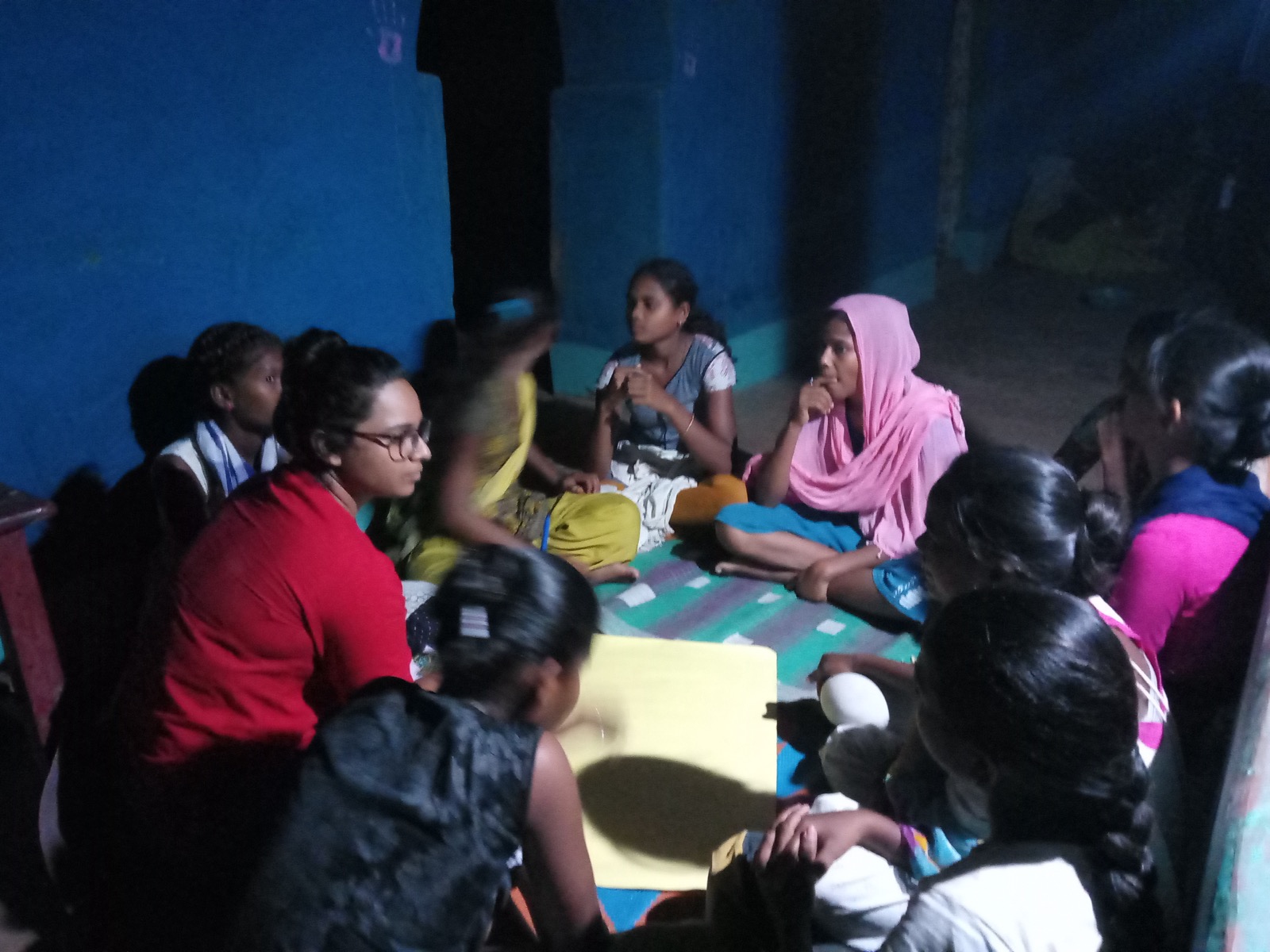 A Chinhari care-group meeting in the evening, members seated in a circle